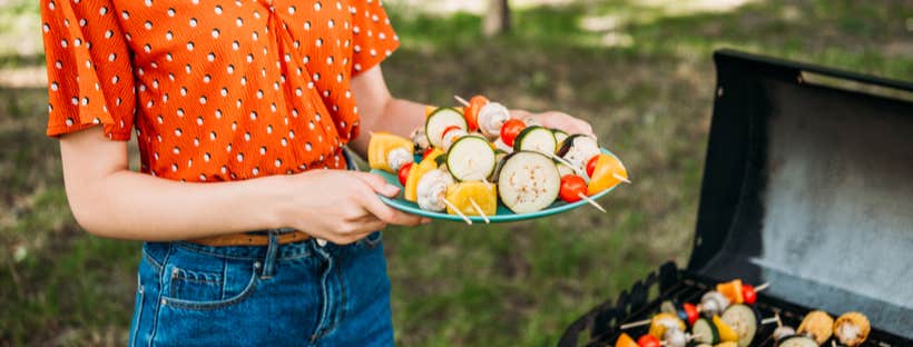 Woman with a plate of vegetable skewers