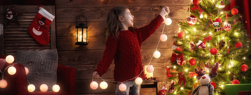 Little girl putting up christmas decorations