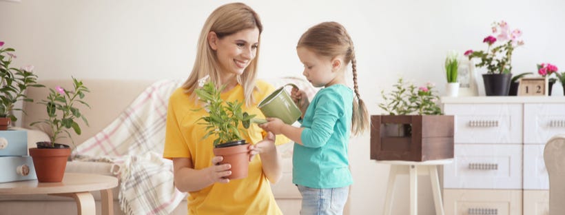 Little girl watering plant